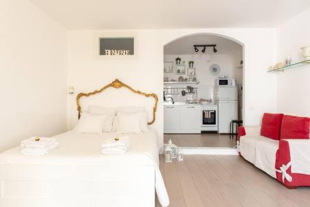 Cosy Home Napoli في نابولي: غرفة نوم بيضاء مع سرير وأريكة