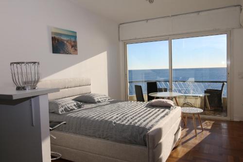 une chambre avec un lit et une vue sur l'océan dans l'établissement Promenade des anglais Vue mer, à Nice