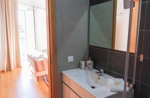a bathroom with a sink and a mirror at Soldouro Guesthouse in Aveiro
