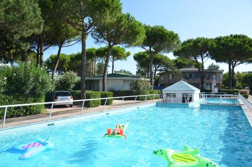 a swimming pool with two people in the water at Villaggio San Siro in Bibione