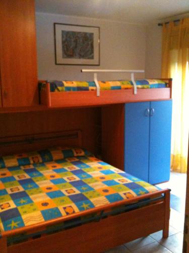 ein Schlafzimmer mit einem Etagenbett mit einer farbenfrohen Tagesdecke in der Unterkunft Taormina Mare Piscina Fondachello in Fondachello