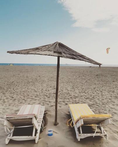 two beach chairs and an umbrella on the beach at Apartments Sija in Ulcinj