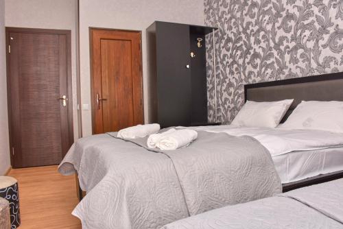 two beds in a hotel room with towels on them at Light House Old City in Akhaltsikhe