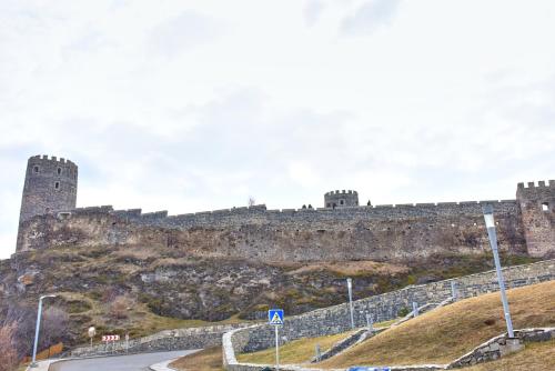 a castle on top of a hill with a road at Light House Old City in Akhaltsikhe