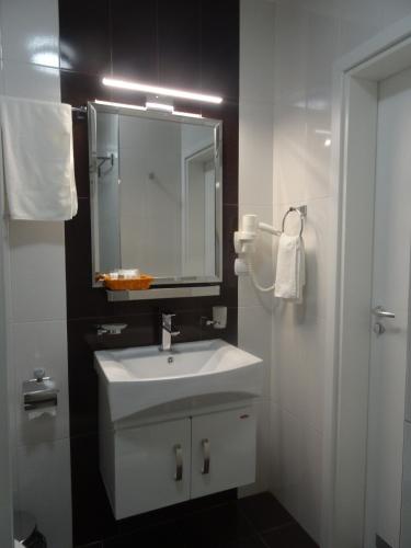 a bathroom with a white sink and a mirror at Апартамент 13 in Hisarya
