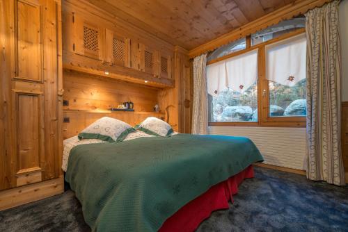 a bedroom with a bed in a room with a window at Hotel Eterlou in Méribel