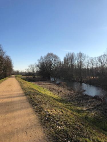 a dirt road next to a river at Gîte Wellness Le Six H in Andolsheim