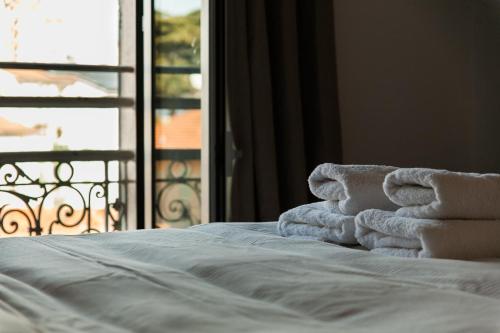 a pile of towels sitting on a bed in front of a window at Joli appartement à côté du Palais des Festivals in Cannes