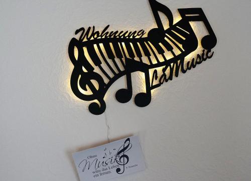 a sign hanging on a wall with a musical instrument at BodenSEE Apartment "La Musica" in Meckenbeuren