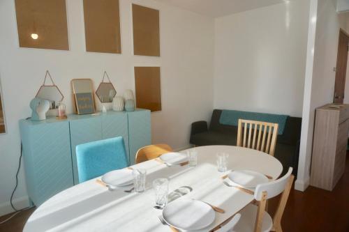a dining room with a white table and chairs at Le 27 - Cosy appartement centre-ville - WIFI in Royan