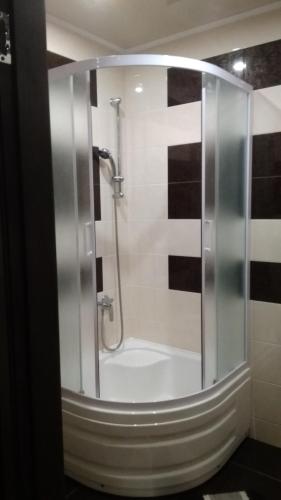 um chuveiro com uma porta de vidro na casa de banho em 35 проспект Миру em Kryvyi Rih