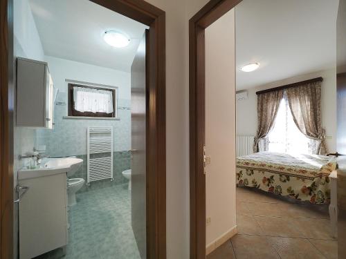 Habitación con baño con cama y lavabo. en Appartamenti Le Terme en Rapolano Terme