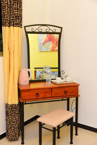 a dressing table with a mirror and a stool at White Villa Airport Transit Hotel in Katunayake