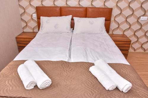 a bedroom with a bed with two white towels on it at Light House Old City in Akhaltsikhe