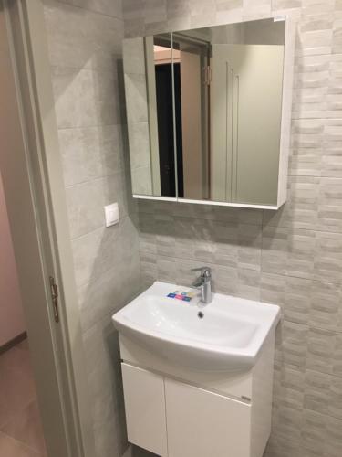 bagno con lavandino bianco e specchio di ApartVel apartment 3 a Velingrad