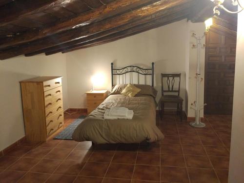 a bedroom with a bed and a dresser and a chair at Casa Rural Vega del Tajuña in Armuña de Tajuña