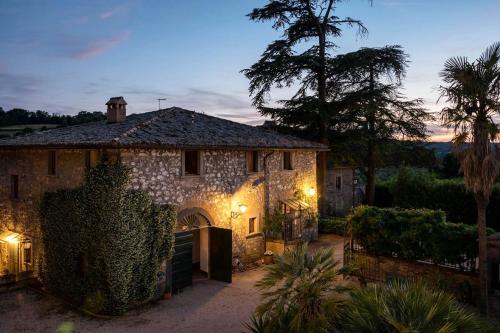 Una gran casa de piedra con luces delante. en Villa Monteporzano en Orvieto