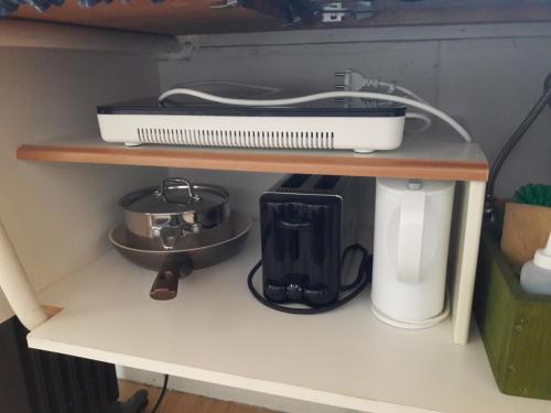 a shelf with a pot and a appliance on it at Fornhagi 2 in Akureyri