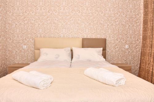 a bed with two white towels on top of it at Light House Old City in Akhaltsikhe