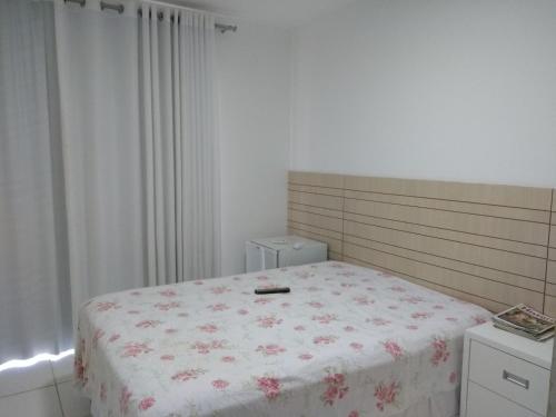 1 Schlafzimmer mit einem Bett mit Blumenbettdecke in der Unterkunft Itacimirim - Quinta das Lagoas Residence in Itacimirim