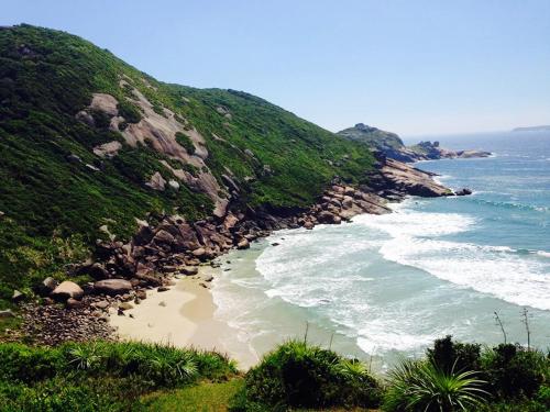 a beach next to the ocean on a hill at BeMyGuest Floripa in Florianópolis
