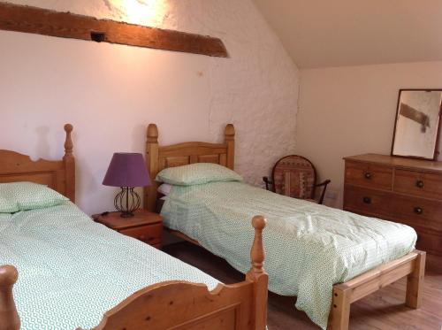 a bedroom with two beds and a dresser at Cutty Sark Cottage in Kirkton of Largo