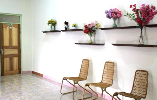 a waiting room with two chairs and flowers at Shifa Lodge Maldives in Feridhoo