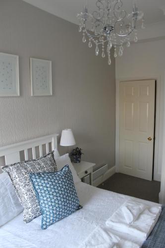 1 dormitorio con cama blanca y lámpara de araña en Dalesgate Lodge, en Skipton