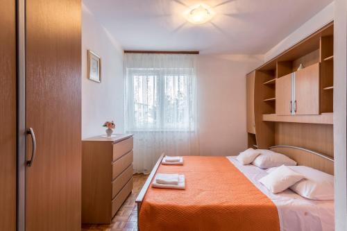 a small bedroom with a bed and a window at Apartment Kossi in Split