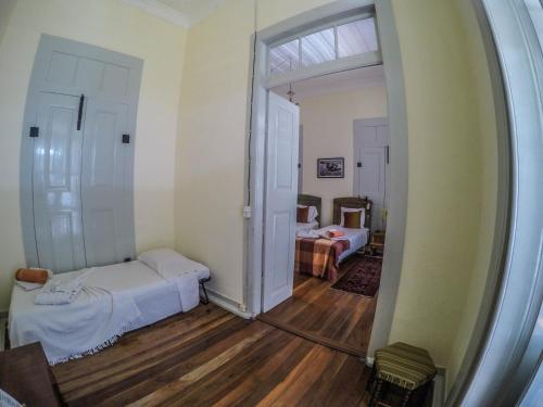 a room with two beds and a mirror at The Colonial Guest House in São Filipe