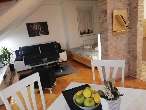 sala de estar con sofá y mesa con un bol de fruta en Two Kings apartment, en Novi Sad
