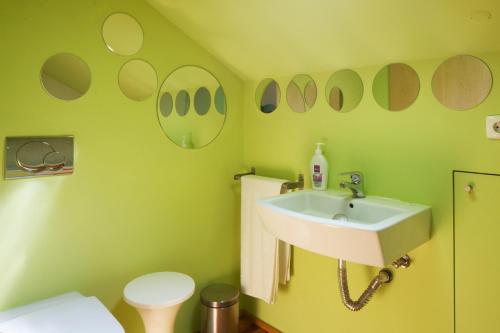 zieloną łazienkę z umywalką i toaletą. w obiekcie Traveling To Lisbon Bairro Alto Apartments w Lizbonie