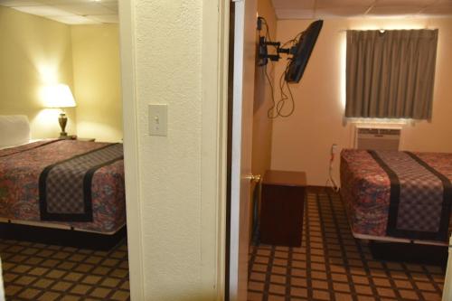 a hotel room with two beds and a television at Extended Stay Motel - Snyder in Snyder