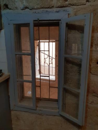 an open window in a brick wall with a view of a window at Nzar Khoury for Hosting in ‘Akko