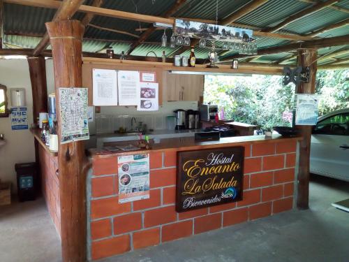 a brick counter with a sign on it at Hostal Encanto La Salada in Jardin