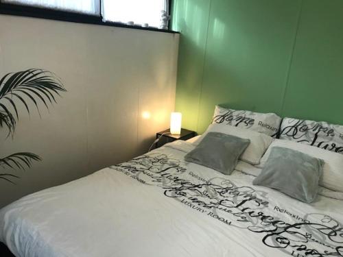 um quarto com uma cama com lençóis brancos e almofadas em Holiday Home 'Beautifull Water' em Lanaken