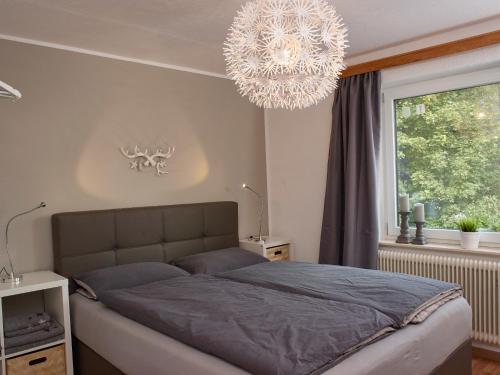 a bedroom with a large bed and a chandelier at Karwendel Apartments II in Scharnitz