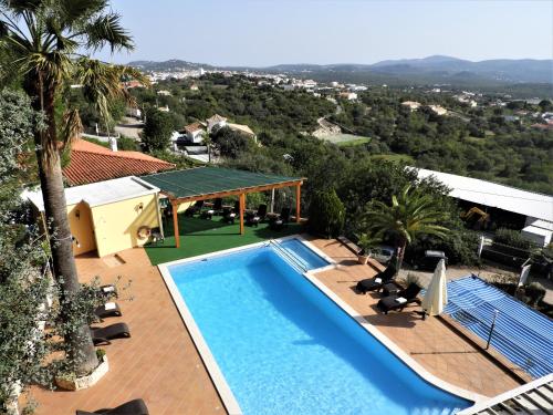 a swimming pool on a roof of a house at Hotel Rural Rocha da Gralheira in São Brás de Alportel