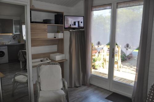 Habitación con una puerta corredera de cristal que da a un balcón. en Chalet, en Plouër-sur-Rance