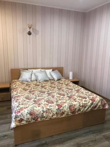 1 Schlafzimmer mit einem Bett mit Blumenbettdecke in der Unterkunft Voyage in Riga