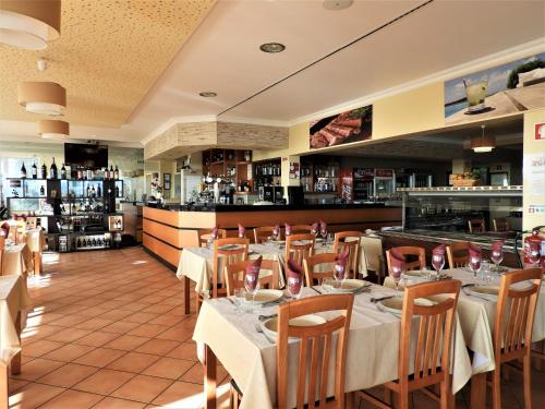 a restaurant with tables and chairs and a bar at Hotel Rural Rocha da Gralheira in São Brás de Alportel