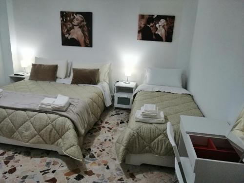 a bedroom with two beds and two pictures on the wall at B&B LA DOLCE VITA in Gragnano