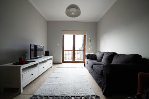 a living room with a couch and a television at Estrela da Serra - Alojamento Local in Penhas da Saúde