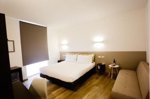 サルザーナにあるSarzana's Roomsのベッドとソファ付きのホテルルーム