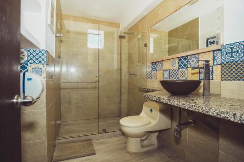 a bathroom with a toilet and a glass shower at Summer House Inn San Andres in San Andrés
