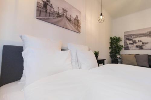 a white bed with white pillows in a bedroom at Standard Apartment by Hi5 - Madách in Budapest