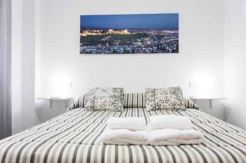 1 dormitorio con 1 cama con toallas en C&V Apartamentos - Horno de Marina, en Granada
