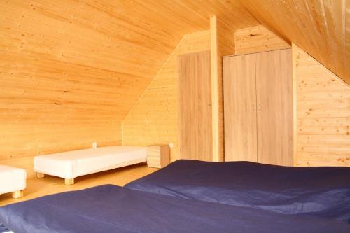 - une chambre avec des murs en bois, un lit et une armoire dans l'établissement Domki Nemo, à Gąski