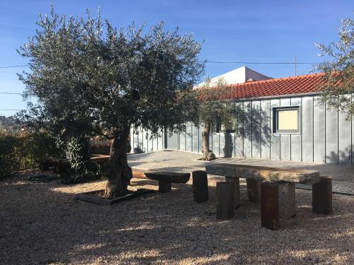 a picnic table and trees in front of a building at Casas do Mondego in Porto da Carne
