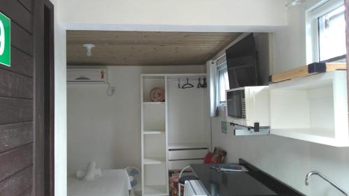 a small kitchen with a sink and a microwave at Pousada Morro do Rosa in Praia do Rosa